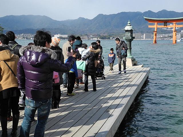 waiting for for a family photo in front of the Itsukushima Shrine